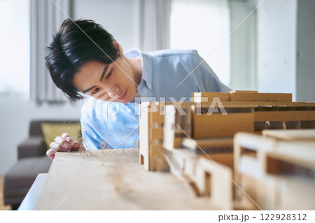 大学の工学部で建築模型を見ながら想像力を働かせて設計しながら建築を考える1人の大学生 122928312