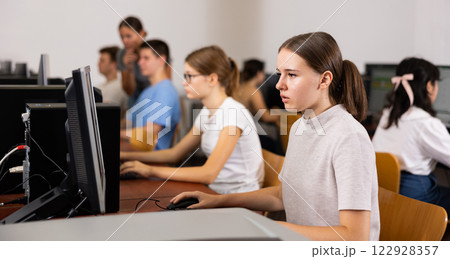 Focused female teenager solving tasks of computer science in the auditory 122928357