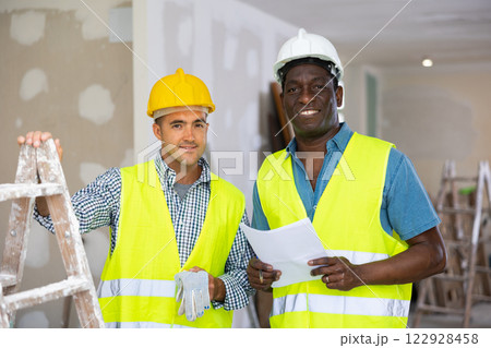 Portrait of two professional builders doing finishing work at cottage Portrait of two professional builders doing finishing work at cottage 122928458