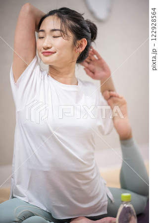 室内でヨガをする若い女性 室内でヨガをする若い女性 122928564