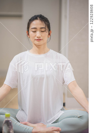 室内でヨガをする若い女性 室内でヨガをする若い女性 122928608