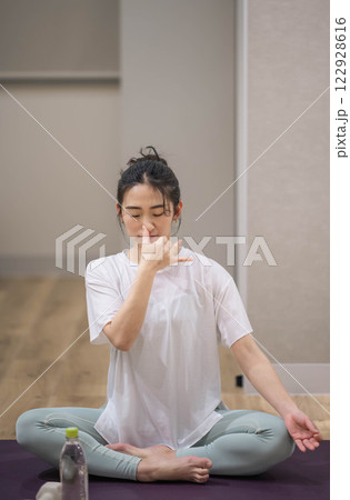 室内でヨガをする若い女性 室内でヨガをする若い女性 122928616