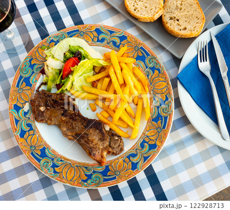 Tasty beef steak slices with French fries and salad 122928713