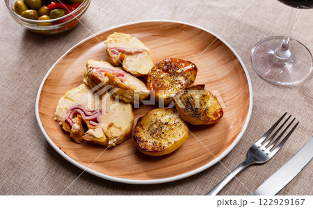 Chicken fillet baked with bacon filling, garnished with fried potato slices. 122929167
