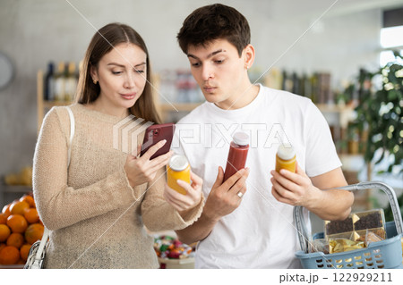 Couple of young man and woman scanning qr code of smoothies 122929211