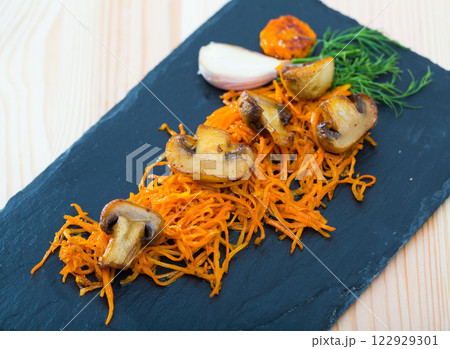 Roasted champignons with julienne carrots 122929301