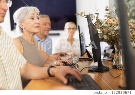 Old woman learning computer programs in training room 122929671