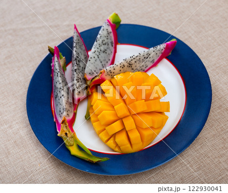 Slices of exotic fruits mango and pitaya closeup 122930041