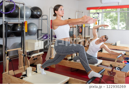 Young woman doing stretching on pilates reformer Young woman doing stretching on pilates reformer 122930269