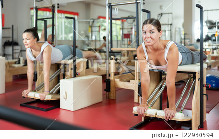 Young woman doing exercises on pilates machine 122930594