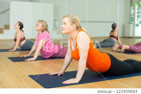 Active senior woman practicing yoga at group Active senior woman practicing yoga at group 122930683