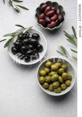 Black, green and kalamata olives with olive branches on marble background 122930696