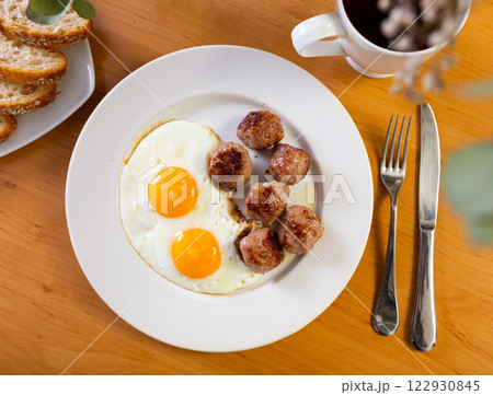 Fried eggs served with meatballs on plate Fried eggs served with meatballs on plate 122930845