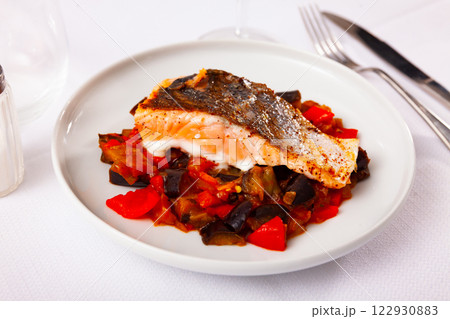 Salmon steak stewed vegetables served on table 122930883