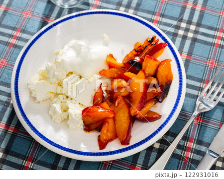 Caramelized peaches and light, tender cottage cheese with sour cream closeup Caramelized peaches and light, tender cottage cheese with sour cream closeup 122931016