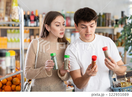 Couple young man and woman choosing spices and seasonings Couple young man and woman choosing spices and seasonings 122931089