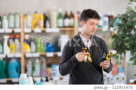 Male client in store inspects set of hand tools. Buyer selects necessary items for minor repairs Male client in store inspects set of hand tools. Buyer selects necessary items for minor repairs 122931478
