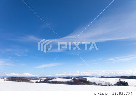 青空に変わった雲が広がる冬の北海道大雪山系の風景 122931774