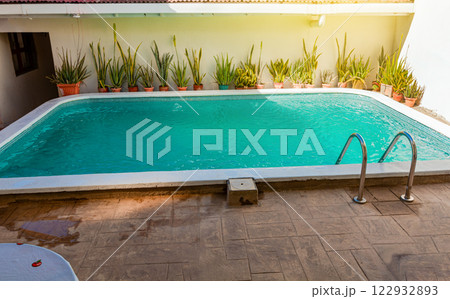 Crystal clear home swimming pool on a sunny day, Concept of home swimming pool designs. Beautiful home swimming pool with crystal clear waters 122932893