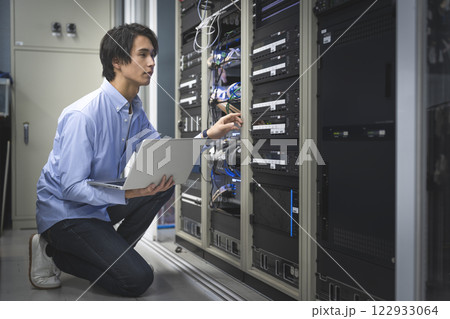 パソコンを持って作業をするITエンジニア 122933064