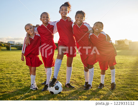 Soccer, team sports and portrait of children training for football game on a grass field together. Happy, smile and young group of girl athletes in partnership and teamwork for sport match at school 122933112