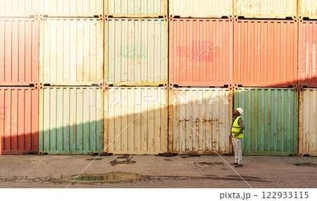 Logistics container, delivery and black man doing inspection of cargo at an outdoor distribution warehouse. African port manager planning shipping of stock while working in the supply chain industry 122933115