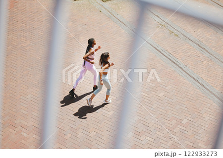 Fitness, exercise and young women running to train for an outdoor sports marathon together. Motivation, training and friends with a healthy, wellness and active lifestyle doing cardio workout outside 122933273