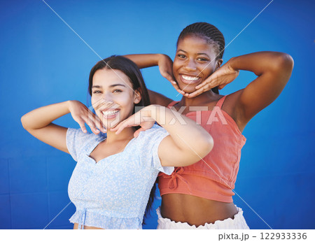 Cute friends happy in studio, women model fashion together on blue background and enjoy summer with portrait. Friendship diversity with funny smile pose, cool black woman and latino girl in Miami 122933336