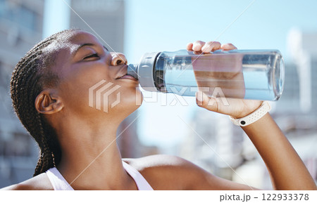 Water bottle, fitness and black woman outside in city for exercise, training and a run for, health wellness and hydration during a workout. Fit athlete female feeling thirsty and drinking pure drink 122933378