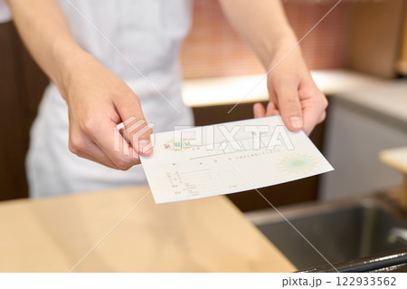領収書を渡す和食の料理人の手元 領収書を渡す和食の料理人の手元 122933562