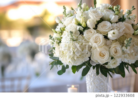 White flower arrangement in glass vase on wedding table 122933608