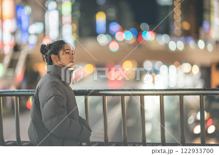 都会の夜景と若い女性ポートレート 122933700