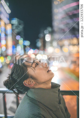 都会の夜景と若い女性ポートレート 122933706