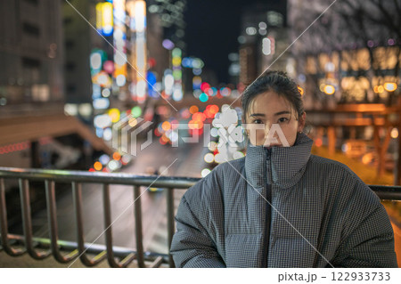 都会の夜景と若い女性ポートレート 122933733