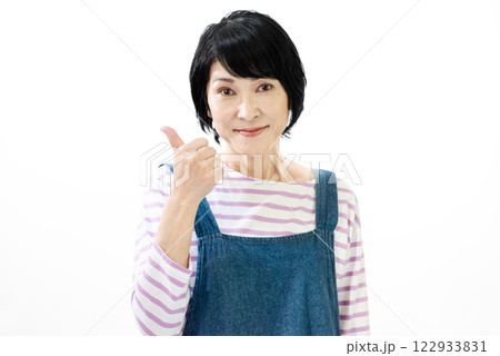 親指を立ててグッドのサインを出すエプロン姿の中年女性 122933831