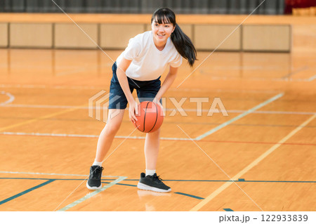 体育館でバスケットをする体操着姿の女子中学生・女子高生 体育館でバスケットをする体操着姿の女子中学生・女子高生 122933839