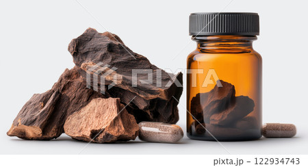 Yohimbe bark and extract in bottle with capsules, showcasing natural health 122934743