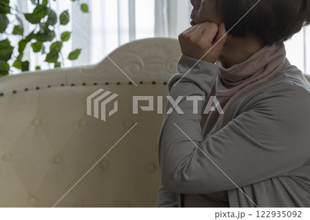 シニア女性がソファーで思い悩む 122935092