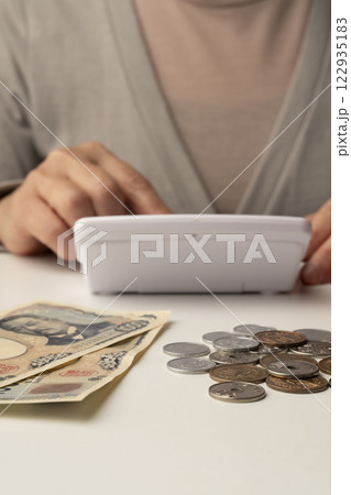 財布に残った現金をテーブルにばら撒く 122935183