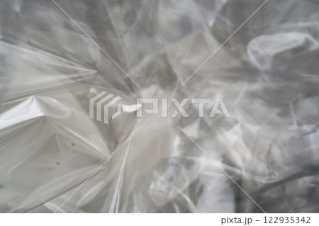 Crumpled clear plastic background, abstract glossy broken surface texture with creases 122935342