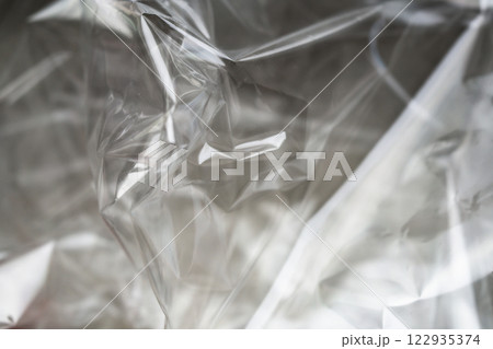 Crumpled clear plastic background, abstract glossy broken surface texture with creases Crumpled clear plastic background, abstract glossy broken surface texture with creases 122935374