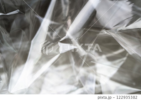 Crumpled clear plastic background, abstract glossy broken surface texture with creases 122935382