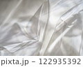 Crumpled clear plastic background, abstract glossy broken surface texture with creases 122935392