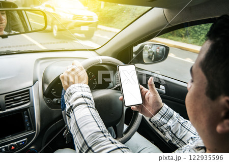 Distracted driver using the cell phone while driving, Man using his phone while driving, Person holding the cell phone and with the other hand the steering wheel, Concept of irresponsible driving Distracted driver using the cell phone while driving, Man using his phone while driving, Person holding the cell phone and with the other hand the steering wheel, Concept of irresponsible driving 122935596