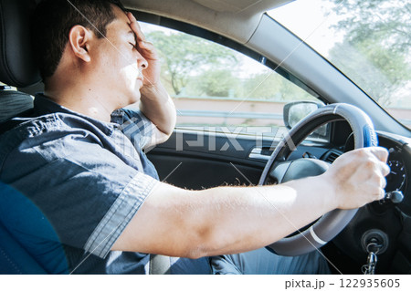 fatigued driver stuck in traffic, concept of a fatigued man in his car, stressed. A driver with a headache in traffic, A person with a headache in traffic fatigued driver stuck in traffic, concept of a fatigued man in his car, stressed. A driver with a headache in traffic, A person with a headache in traffic 122935605
