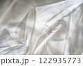 Crumpled clear plastic background, abstract glossy broken surface texture with creases 122935773