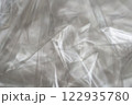 Crumpled clear plastic background, abstract glossy broken surface texture with creases 122935780