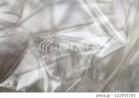 Crumpled clear plastic background, abstract glossy broken surface texture with creases Crumpled clear plastic background, abstract glossy broken surface texture with creases 122935783
