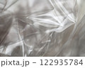 Crumpled clear plastic background, abstract glossy broken surface texture with creases 122935784