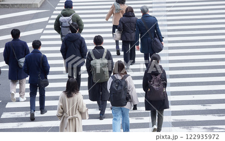 ハイアングルで撮影した冬の朝の都市の交差点で横断歩道を渡る人々の姿 ハイアングルで撮影した冬の朝の都市の交差点で横断歩道を渡る人々の姿 122935972